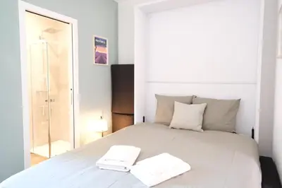 a bedroom with a white bed with two towels on it at Studio rénové avec belle terrasse in Aix-en-Provence