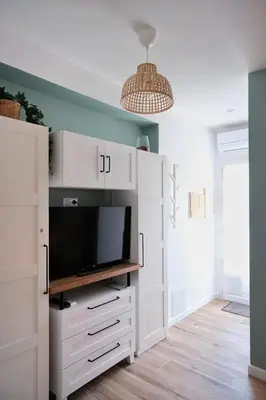 a living room with a tv and white cabinets at Studio rénové avec belle terrasse in Aix-en-Provence