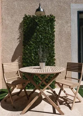 a picnic table and two chairs next to a wall at Studio rénové avec belle terrasse in Aix-en-Provence