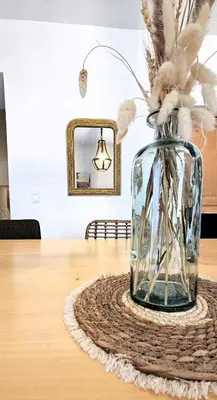 a vase with feathers in it sitting on a table at Mas Les Fabrys au coeur du Luberon in Bonnieux
