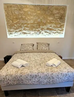 a bedroom with a bed with two towels on it at Mas Les Fabrys au coeur du Luberon in Bonnieux