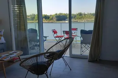 a room with a balcony with chairs and a table at Appartement climatisé au coeur de la Provence lac et parcs d'attractions 10mn Avignon in Monteux
