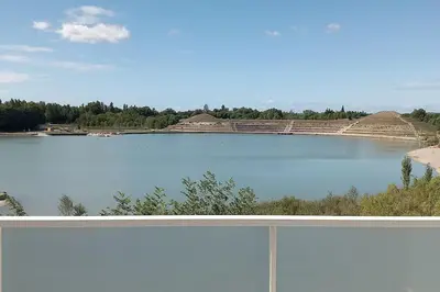 a view of a large lake with a building at Appartement climatisé au coeur de la Provence lac et parcs d'attractions 10mn Avignon in Monteux