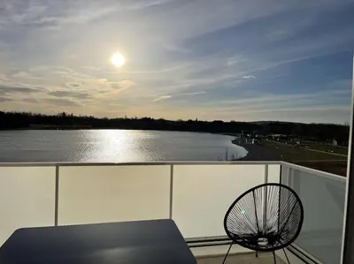 a balcony with a bench and a view of a river at Appartement climatisé au coeur de la Provence lac et parcs d'attractions 10mn Avignon in Monteux