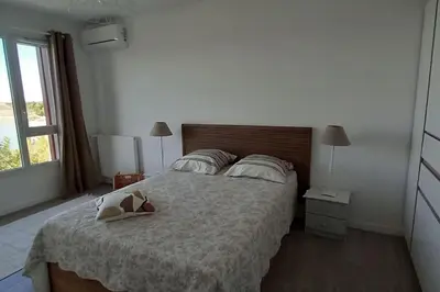 a bedroom with a bed with a stuffed animal on it at Appartement climatisé au coeur de la Provence lac et parcs d'attractions 10mn Avignon in Monteux
