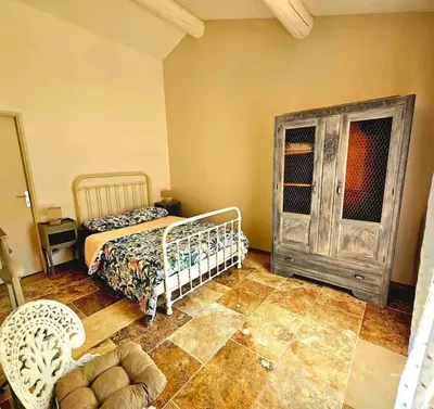 a bedroom with a bed and a cabinet in a room at La Castellane, vue imprenable sur le Luberon in Saignon