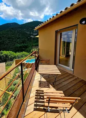 a wooden deck with a table and chairs on it at La Castellane, vue imprenable sur le Luberon in Saignon