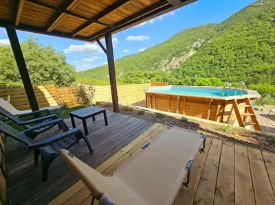 a deck with a pool and a table and chairs at La Castellane, vue imprenable sur le Luberon in Saignon