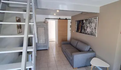 a living room with a couch and a bunk bed at La Passiflore in Mazan