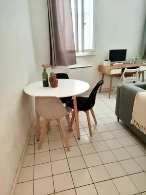 a white table and chairs in a room with a couch at Le Tanneur- Grand Studio 38m2 en centre-ville in Aix-en-Provence