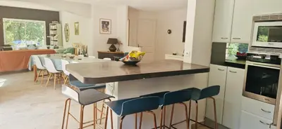 a kitchen and dining room with a table and chairs at La Maison du Soleil in Saint-Didier