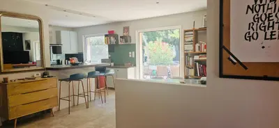 a kitchen with a bar with stools and a window at La Maison du Soleil in Saint-Didier