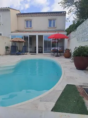a large blue swimming pool in front of a house at Jolie petite maison tout proche d avignon in Vedène