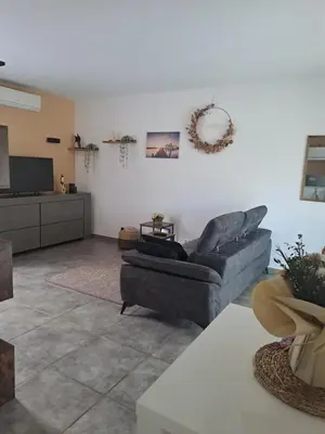 a living room with a couch and a tv at Jolie petite maison tout proche d avignon in Vedène