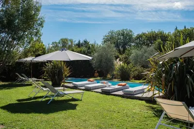 a backyard with a pool with chairs and an umbrella at Maison Jalon in Aix-en-Provence