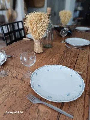 a wooden table with plates and forks and glasses at La Maison de Papé et Mamé in LʼIsle-sur-la-Sorgue
