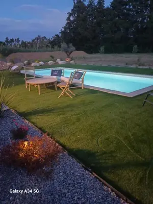a swimming pool with two lounge chairs and a table at La Maison de Papé et Mamé in LʼIsle-sur-la-Sorgue