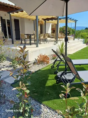 a patio with two lawn chairs and an umbrella at La Maison de Papé et Mamé in LʼIsle-sur-la-Sorgue