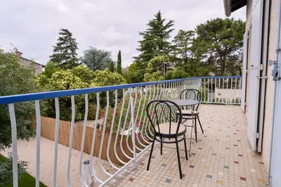 a patio with two chairs and a table on a balcony at Maison familiale avec jacuzzi, quartier calme in Avignon