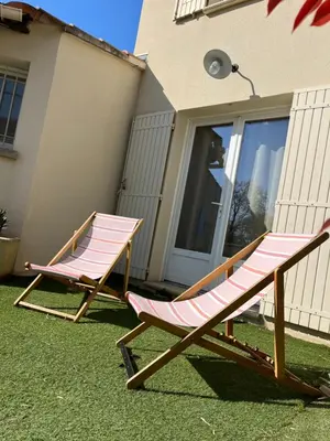 two lawn chairs sitting on the grass in front of a house at La maison en couleurs 3 étoiles, du calme à 10 minutes d'Avignon in Vedène