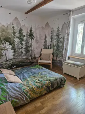 a bedroom with a mural of trees on the wall at La maison de Campagne - RENDEZ-VOUS EN PROVENCE in Monteux