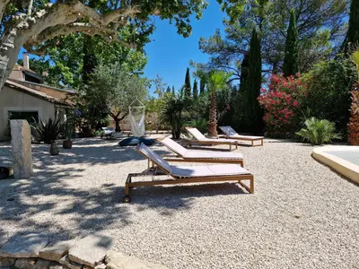 a row of lounge chairs sitting in a courtyard at La maison de Campagne - RENDEZ-VOUS EN PROVENCE in Monteux