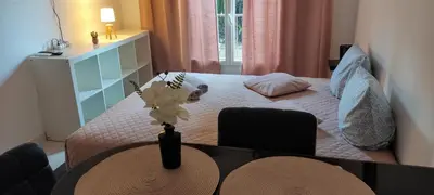 a room with a bed with a table with a vase with flowers at Provençal-style apartment in Aix-en-Provence