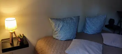 a bedroom with a bed with blue pillows and a lamp at Provençal-style apartment in Aix-en-Provence