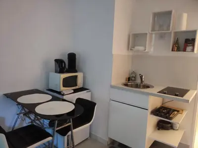 a small kitchen with a small table and a microwave at Provençal-style apartment in Aix-en-Provence