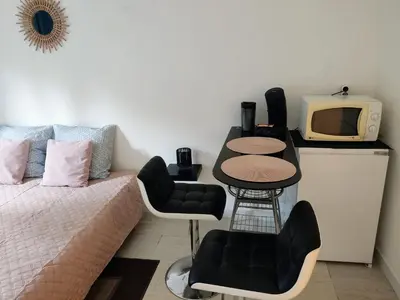 a room with a bed and a tv and a table at Provençal-style apartment in Aix-en-Provence