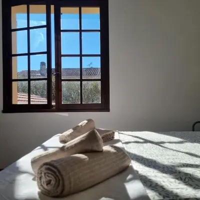 two towels sitting on a bed in front of a window at Villa l'Olivier en Provence 5ch piscine jardin et clim in Lambesc