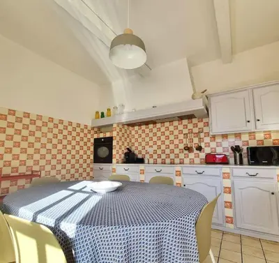 a kitchen with a table with a blue and white table cloth at Villa l'Olivier en Provence 5ch piscine jardin et clim in Lambesc