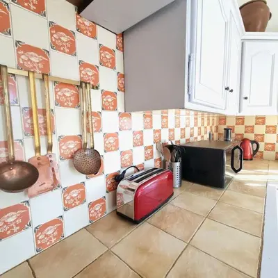 a kitchen with a tiled wall with a toaster at Villa l'Olivier en Provence 5ch piscine jardin et clim in Lambesc