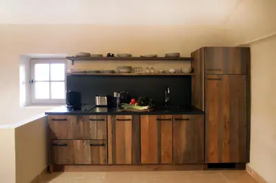 a kitchen with wooden cabinets and a counter top at Domaine des Peyre in Robion en Luberon