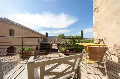 a patio with a table and chairs on a balcony at Domaine des Peyre in Robion en Luberon