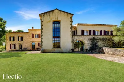 an old stone house with a grass yard at Bastide Domaine Tour Campanets in Le Puy-Sainte-Réparade
