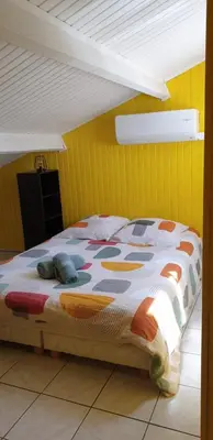 a bed in a room with a yellow wall at Chambre étudiant in Morières-lès-Avignon