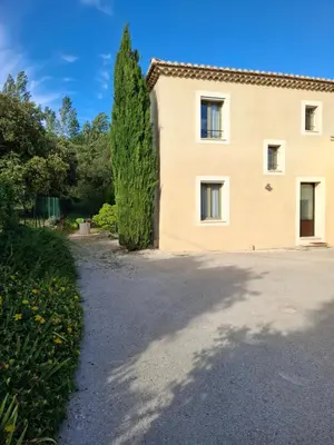 a house with a large driveway and a tree at La gloriette in Saumane-de-Vaucluse