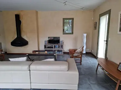 a living room with a white couch and a guitar at La gloriette in Saumane-de-Vaucluse