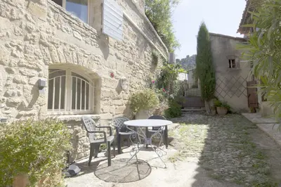 a patio with a table and chairs next to a building at Les trois gites in Robion en Luberon