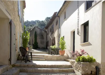 an alley with stairs and a table and chairs at Les trois gites in Robion en Luberon