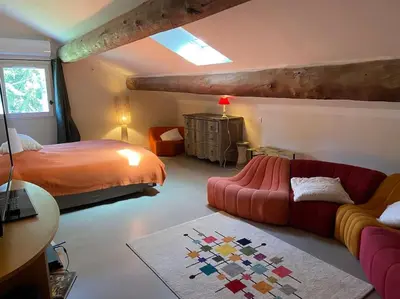 a bedroom with a bed and a red couch at Le Mas Carradou , Mas de Prestige en campagne in Monteux