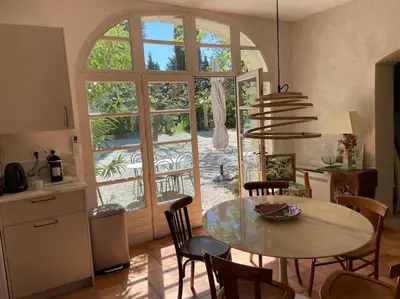 a kitchen and dining room with a table and a window at Le Mas Carradou , Mas de Prestige en campagne in Monteux