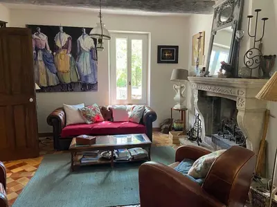 a living room with a couch and a fireplace at Le Mas Carradou , Mas de Prestige en campagne in Monteux