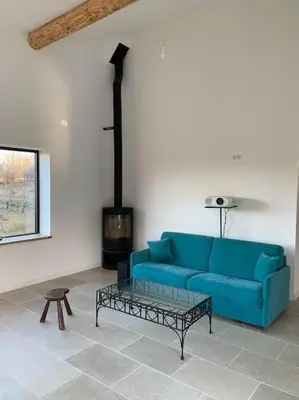 a blue couch in a living room with a fireplace at Havre de paix sur Roussillon in Roussillon
