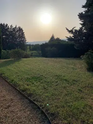 a field of grass with the sun in the distance at Havre de paix sur Roussillon in Roussillon