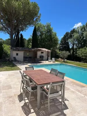 a table and chairs next to a swimming pool at Havre de paix sur Roussillon in Roussillon