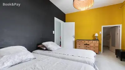 a bedroom with two beds and a yellow wall at Villa confortable à Morières-lès-Avignon avec jardin privé in Morières-lès-Avignon