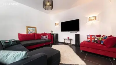 a living room with two couches and a flat screen tv at Villa confortable à Morières-lès-Avignon avec jardin privé in Morières-lès-Avignon