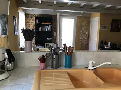 a kitchen counter with a sink with utensils at maison familiale in Saint-Trinit